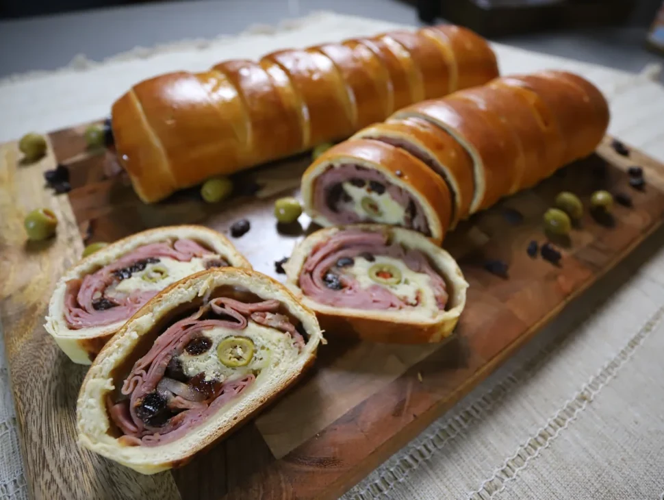 Pan de jamón completo y rebanadas sobre una tabla de madera