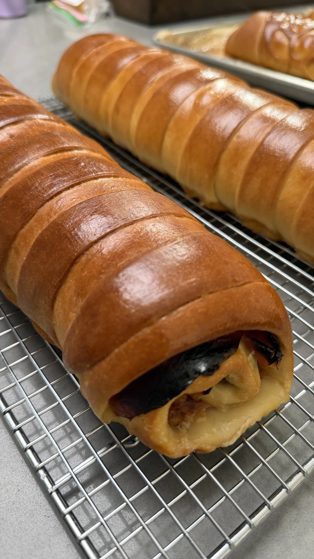 Pan de jamón dorado sobre una rejilla, con parte del relleno visible